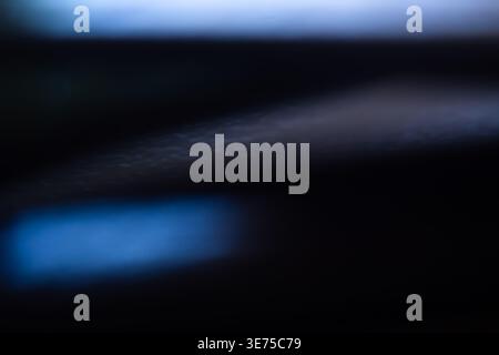Fond abstrait foncé avec des fusées lumineuses bleues douces et des ombres profondes Banque D'Images