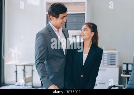 Portrait d'un couple d'affaires asiatique heureux debout ensemble. Jeune homme et femme professionnels souriant en studio. Concept de travail d'équipe d'entreprise Banque D'Images