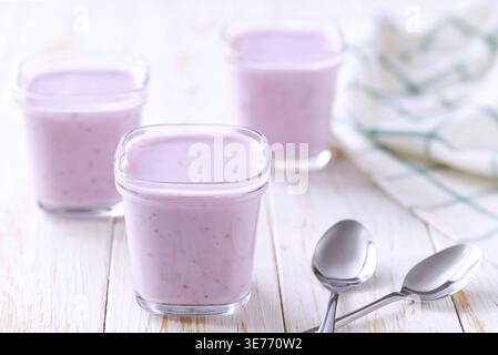 Smoothie aux fruits maison dans un bocal en verre avec des cuillères sur une table lumineuse, mise au point sélective Banque D'Images