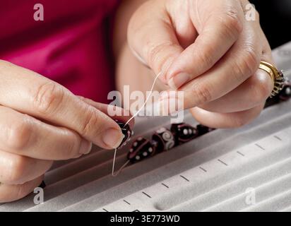 Close up d'enfiler des perles sur le fil de collier de perles bracelet ou artistique Banque D'Images
