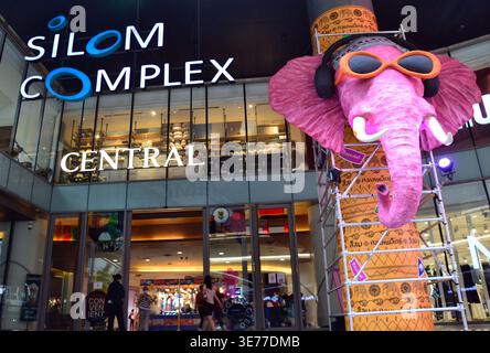 Une grande image d'éléphant de dessin animé annonçant le festival de l'eau de Songkran "Sawasdee Silom Land" devant le centre commercial Silom Complex dans le quartier Silom de Bangkok, en Thaïlande. Le festival de l'eau a lieu du 12 au 15 avril 2026, et mettra en vedette des foules trempant les uns les autres avec des pistolets à eau. Ce qui a commencé par verser doucement de l'eau sur les images de Bouddha et les aînés pour les bénédictions a évolué en célébrations nationales animées de jet d'eau. Le symbolisme est qu’il représente la purification – laver la malchance de l’année précédente et accueillir la nouvelle année avec de la chance. Banque D'Images