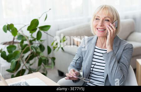 Femme d'affaires senior parlant au téléphone, consultant les clients Banque D'Images