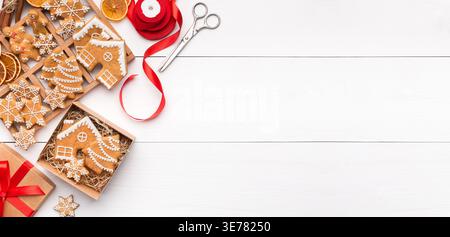 Biscuits de pain d'épices de Noël dans la boîte sur fond en bois blanc Banque D'Images