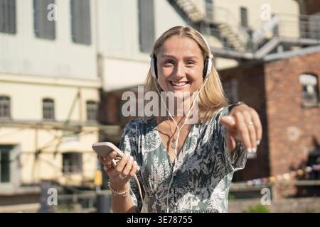 Jeune femme pointant vers la caméra créant un contenu de style de vie attrayant Banque D'Images