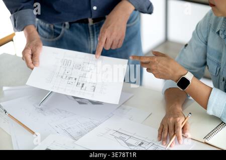 L'architecte ou l'ingénieur examine et vérifie les détails de la conception du bâtiment pour voir si elle répond aux objectifs de planification de l'administrateur Banque D'Images