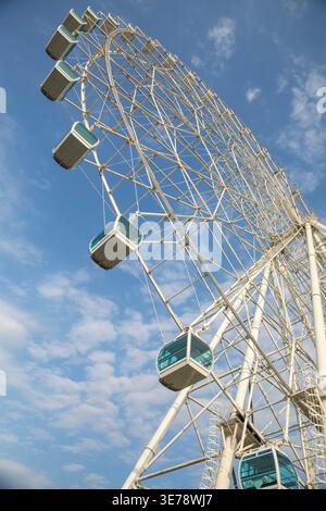 Une grande grande roue d'observation avec des gondoles fermées pour passagers se dresse bien en évidence contre un ciel bleu partiellement nuageux à Foz do Iguacu, Parana, Brésil Banque D'Images