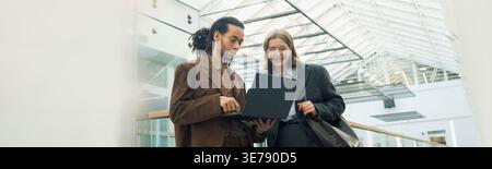 Homme et femme adulte examinant l'ordinateur portable pour la planification d'entreprise Banque D'Images