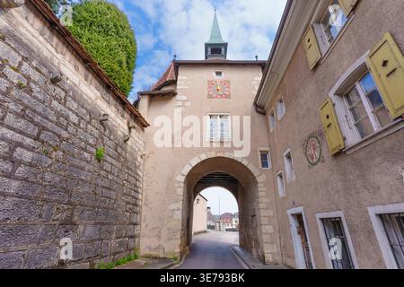 Porrentruy, Suisse - 23 mars 2026 : la porte historique voûtée connue sous le nom de porte de France présente un cadran d'horloge proéminent et des murs en pierre altérée i. Banque D'Images