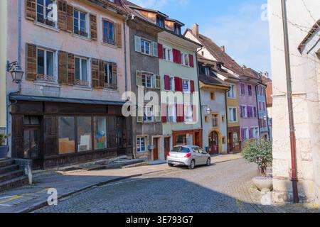 Porrentruy, Suisse - 23 mars 2026 : charmants bâtiments traditionnels avec volets en bois bordent une étroite rue pavée dans la ville historique de Porrentruy, Banque D'Images