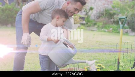 Guider l'homme et le garçon versant de l'eau d'un grand arrosoir dans la jardinière dans l'arrière-cour, portant un gant Banque D'Images