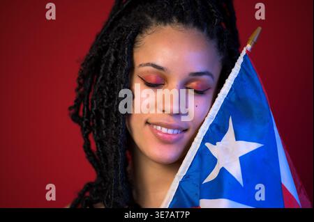 Femme afro-latina tenant un drapeau portoricain Banque D'Images