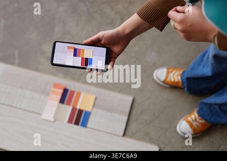 Mains de concepteur féminin mixte-race prenant en photo la palette de couleurs tout en se tenant debout dans le bureau Banque D'Images