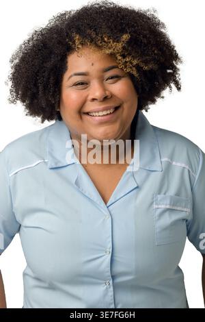 Femme hispanique de grande taille souriante avec afro bouclé portant du bleu debout sur fond blanc en studio Banque D'Images