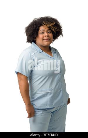 Femme hispanique de grande taille avec afro bouclé portant un uniforme bleu debout sur fond blanc en studio Banque D'Images