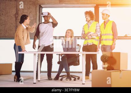 Homme noir utilisant des lunettes de VR tout en rencontrant des gens d'affaires sur le chantier de construction Banque D'Images