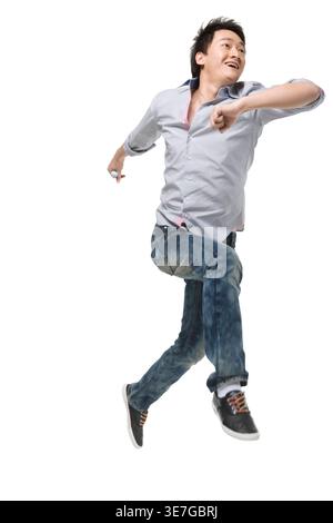 Homme chinois portant des manches longues courant sur fond blanc en studio Banque D'Images