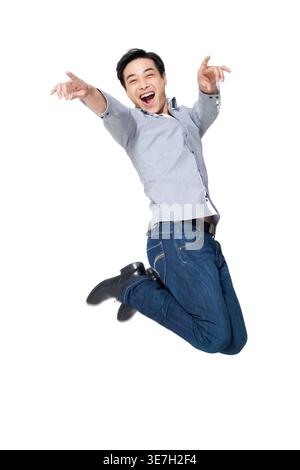 Joyeux homme chinois portant des manches longues sautant sur fond blanc en studio Banque D'Images