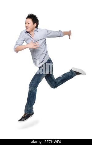 Homme chinois portant des manches longues courant sur fond blanc en studio Banque D'Images