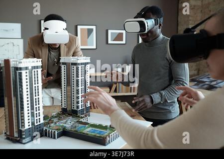 Divers architectes de groupe utilisant des casques VR pendant le travail avec aménagement de la maison au bureau Banque D'Images