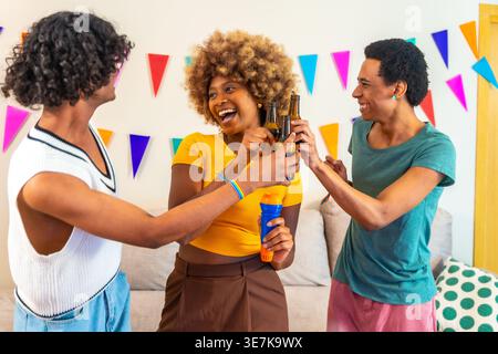 Groupe d'amis joyeux et diversifié appréciant de griller dans une partie karaoké à la maison Banque D'Images