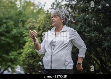 Femme noire plus âgée faisant du Tai Chi en plein air Banque D'Images