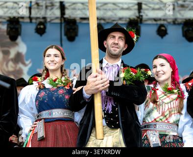 Villach, Autriche - 27 juillet 2025 : le festival Villacher Kirchtag présente trois personnes en tenue traditionnelle, incarnant la culture et la communauté locales Banque D'Images