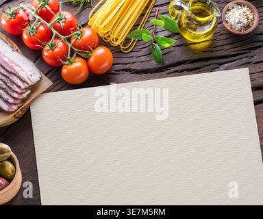 Assortiment de nourriture méditerranéenne sur une table en bois rustique. Le papier blanc au centre fournit un espace de copie pour les recettes, les menus ou les concepts alimentaires. Banque D'Images
