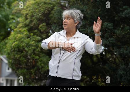 Femme noire plus âgée faisant du Tai Chi en plein air Banque D'Images