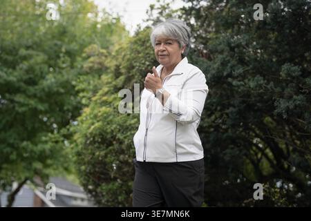 Femme noire plus âgée faisant du Tai Chi en plein air Banque D'Images