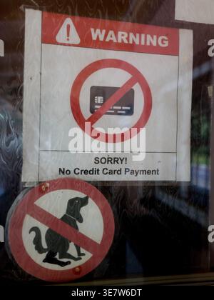Panneaux d'avertissement sur une porte vitrée interdisant les paiements par carte de crédit et l'entrée avec des chiens en République tchèque Banque D'Images