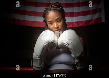 Boxeur féminin noir portant des gants debout dans un ring de boxe Banque D'Images