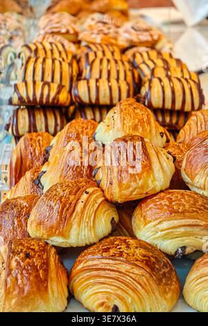 Croissants et pâtisseries variées empilées, prêtes pour le petit déjeuner et des collations, marché San Miguel Madrid. Banque D'Images