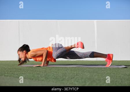 Femme asiatique faisant un push-up avancé avec crunch côté jambe à la salle de gym en plein air Banque D'Images