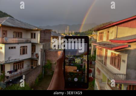 Srinagar, Inde. 11 avril 2026. Un homme prend des photos d'arc-en-ciel à Srinagar, la capitale estivale du Jammu-et-Cachemire. Crédit : SOPA images Limited/Alamy Live News Banque D'Images