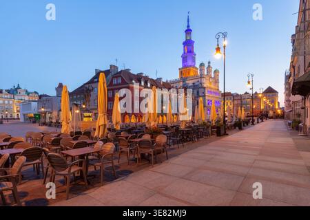 Vue tôt le matin de l'hôtel de ville de Poznan depuis une rue calme sur la place du vieux marché, Poznan, Pologne, avec des façades illuminées à l'heure bleue avant le soleil Banque D'Images