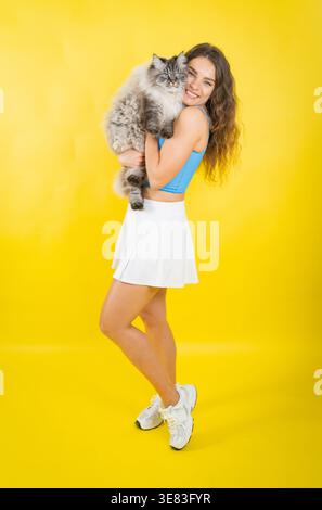 Jeune femme embrassant le chat animal fourré avec joie Banque D'Images