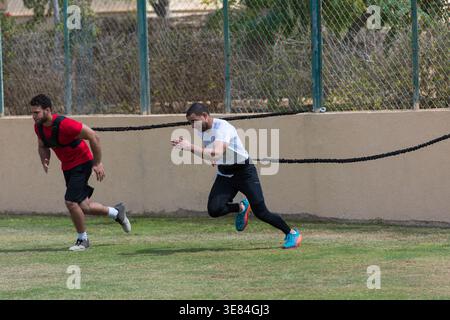 Homme du moyen-Orient et ami faisant un entraînement de sprint de résistance CrossFit en plein air dans un gymnase de fitness en espace ouvert Banque D'Images