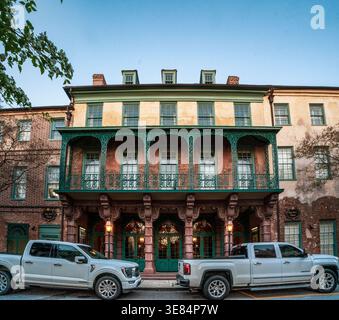 Charleston, SC - US - 27 mars 2026 L'historique théâtre Dock Street brille au crépuscule, son balcon orné de ferronnerie et sa façade en briques altérées capturent TI Banque D'Images