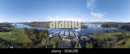 Vue aérienne des bateaux amarrés à la marina, reflétant le ciel dégagé, nichés entre les collines verdoyantes et le lac calme, Bowness-on-Windermere, Angleterre, Banque D'Images