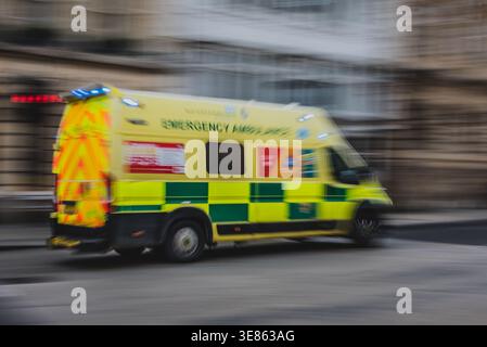 Une ambulance du NHS accélère sur une route britannique avec des feux allumés, Oxford, Royaume-Uni Banque D'Images