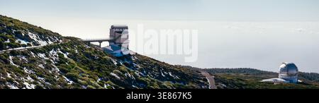 Vue panoramique de l'observatoire Roque de los Muchachos sur l'île de la Palma, Espagne, avec des dômes de télescope modernes, route sinueuse, et pente volcanique accidentée U. Banque D'Images