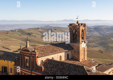 Paysage matinal captivant à Piamonte, en Italie, présentant des collines ondulantes, des vignobles luxuriants, et une église historique sous un ciel clair, reflétant la re Banque D'Images