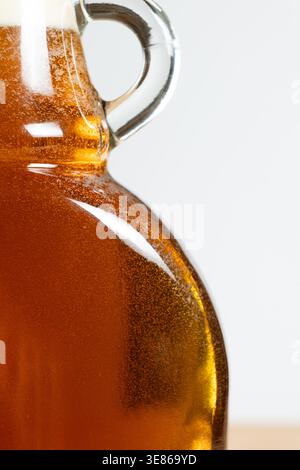 Gros plan du sirop d'érable doré dans une bouteille en verre. Banque D'Images