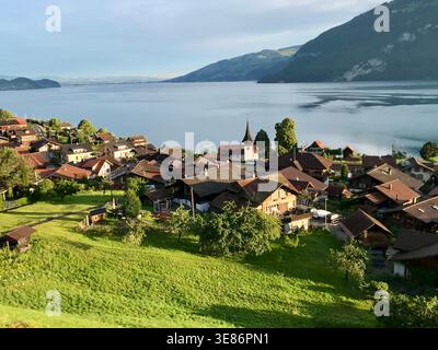 Village de Leissigen au lac de Thoune en lumière dorée du matin avec Green Meadows, Oberland bernois, Suisse Banque D'Images