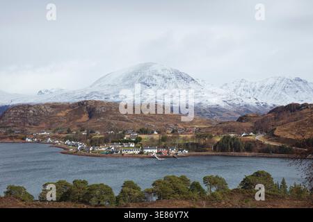 Village Shieldaig sur la rive du Loch Shieldaig avec des montagnes enneigées derrière en hiver, Wester Ross, Highlands écossais, Écosse, Royaume-Uni Banque D'Images