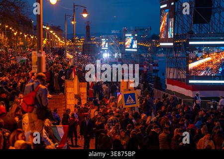 Budapest, Hongrie - 12 avril 2026 : une foule dense de partisans se rassemble au crépuscule le long du remblai de Budapest pour attendre les résultats des élections de 2026 pour t Banque D'Images
