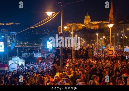 Budapest, Hongrie - 12 avril 2026 : cette photographie nocturne grand angle capture l'ampleur d'un rassemblement politique le long du Danube. Avec grand creusement Banque D'Images