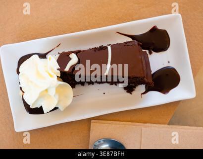 Savoureuse tranche de gâteau au brownie posée de façon décorative sur une assiette Banque D'Images