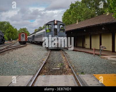 Sacramento, Californie, États-Unis - 12 avril 2026 : la locomotive diesel Sacramento Southern Railroad SSRR 2030 tire des voitures de tourisme devant un s en bois rustique Banque D'Images