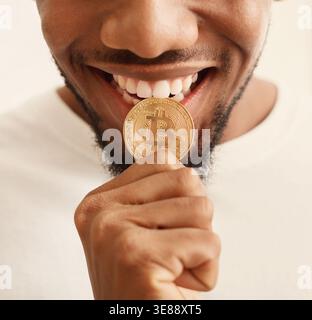 Black man biting bitcoin or close up Banque D'Images